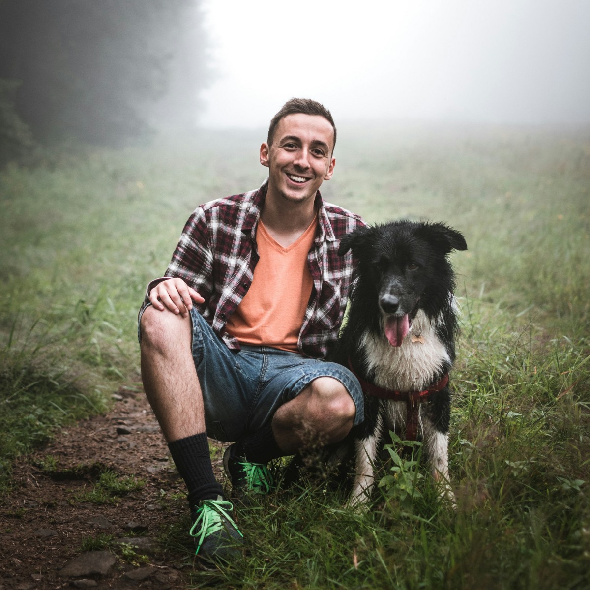 man and his dog are seen on a foggy trail man and his dog sitting on grass